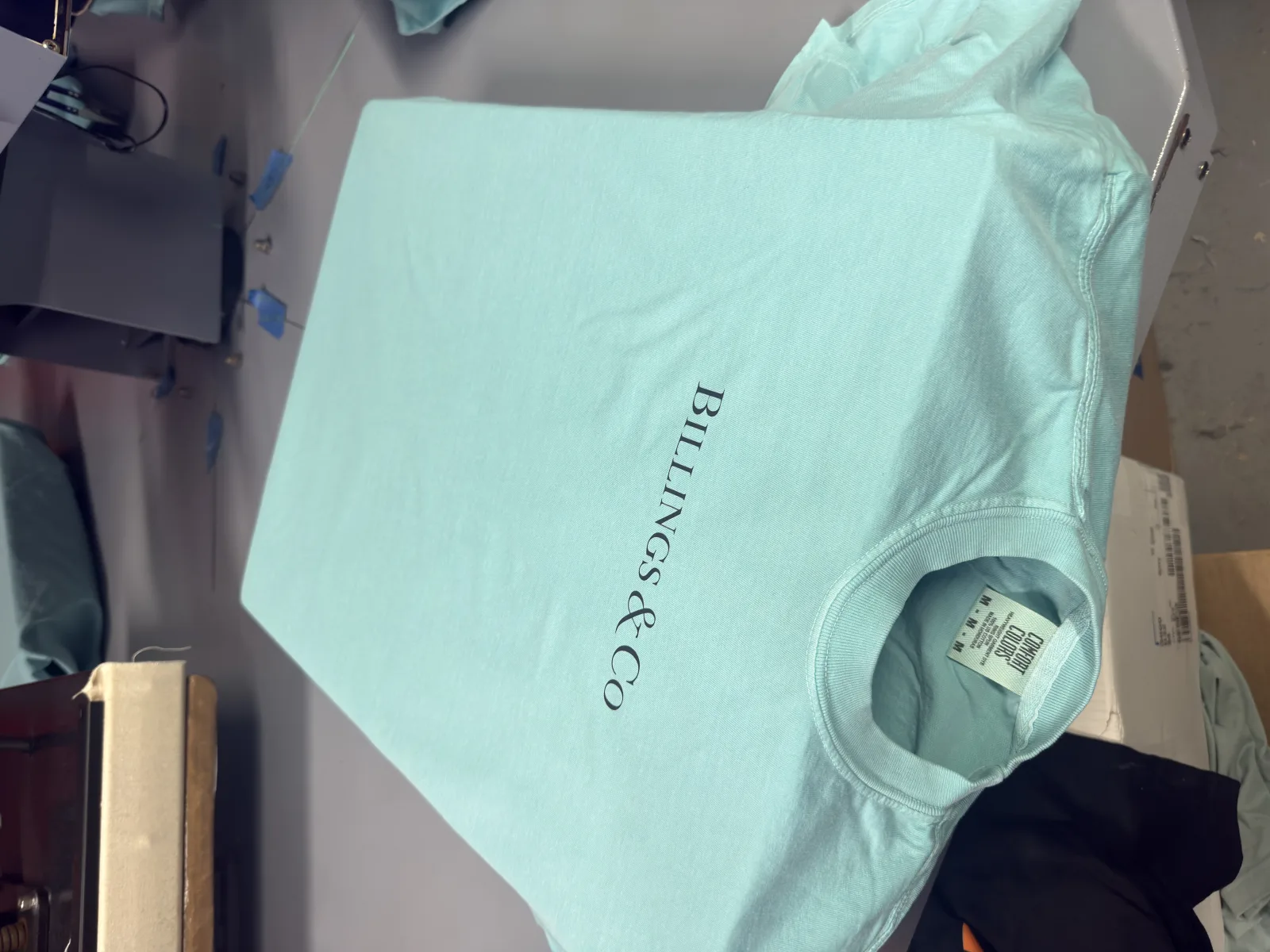 Mint shirt with Billings & Co branding on a heat press